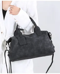 Close-up of black retro crossbody bag with matte texture and dual handles