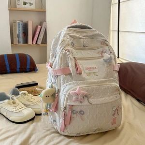 Detail of white quilted backpack with colorful bow embroidery and multi-layer zipper pockets