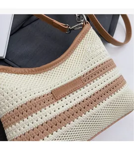 Detail of woven beach tote with brown leather trim and Solar & Miss brand logo plate