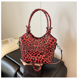 Close-up of leopard print handbag with knotted handle and detachable shoulder strap