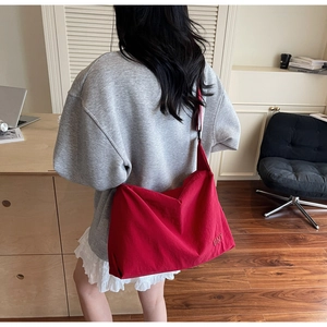 Détail du grand sac en toile rouge avec bandoulière large et broderie BNT