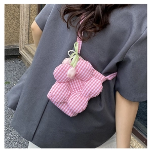 Detail view of pink and white checkered flower petal shaped crossbody bag with silk bow