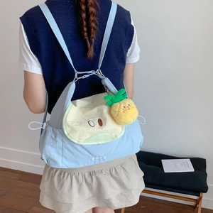 Vue arrière d'un sac à dos en toile bleu clair avec pendentif ananas et broderie Pear