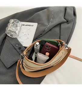 Detail showing high storage capacity of the striped knit crossbody bag with two smartphones