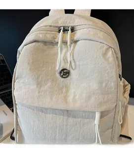 Detail of light beige backpack showing water-resistant nylon texture and metal zippers