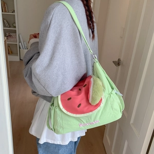 Détail d'un sac à bandoulière aux motifs pastèque avec broderie et charme en peluche