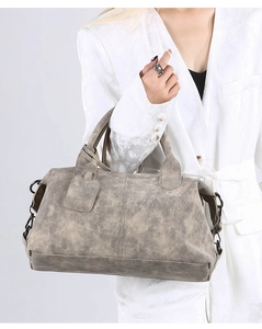 Detail of vintage tote bag with soft leather texture and metallic D-ring attachment