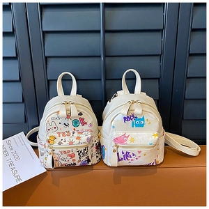Detail of white mini backpack featuring colorful cartoon graffiti and cute animal prints