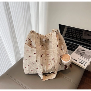Detail of off-white canvas tote with red bows and cute cupcake heart charm