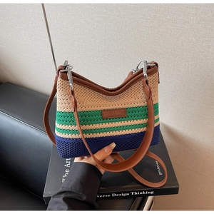 Detail of striped knit tote bag with brown leather handles and logo patch on art book