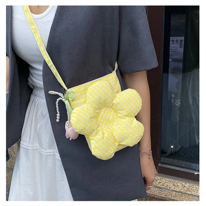 Detail view of yellow checkered flower-shaped canvas bucket bag with pearl tulip strap