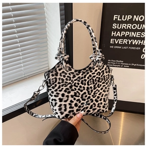 Detail of trendy leopard print handbag with knotted round handle and wavy edge design