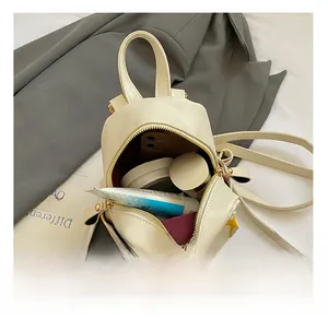 Detail shot of the cream mini backpack interior showing its capacity for daily essentials