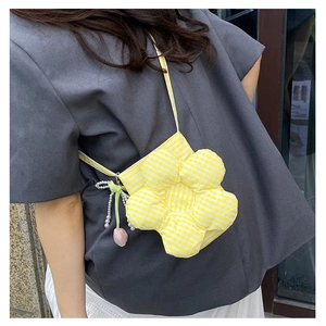 Detail of yellow flower-shaped crossbody bag with pearl charms and checkered fabric pattern