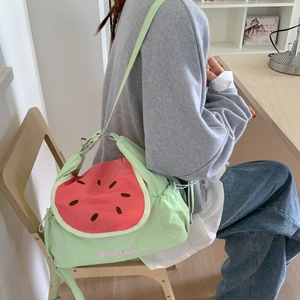 Détail du sac bandoulière en toile pastèque avec rabat rose et broderies décoratives
