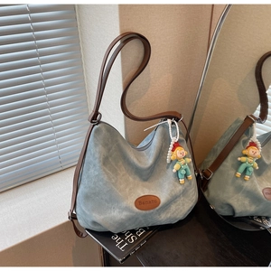 Détail du sac cabas Banatu avec un charm de personnage mignon et des anses en cuir