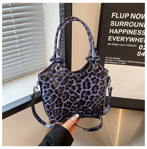 Detail of purple leopard print patent leather tote bag with glossy finish and metal ring handles