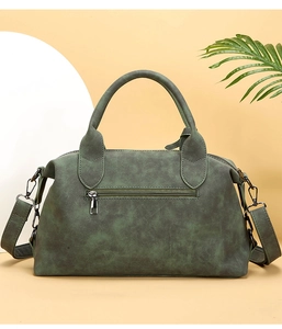Detail showing the dark green matte texture and back zipper pocket of the vintage bag