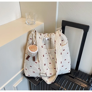 Detail of waffle fabric tote bag with red bow pattern and cute coffee cup pendant