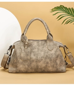 Macro detail of vintage textured leather crossbody bag with metallic zipper and top handles