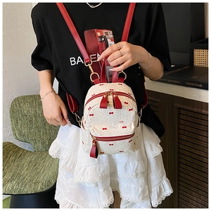 Detail of woven mini backpack with red bow embroidery and red PU leather straps