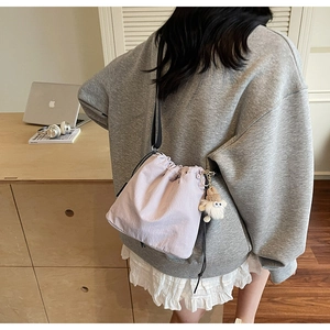 Mini sac seau lavande avec cordon de serrage et charm en peluche dans un décor moderne