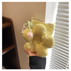 Detail of yellow striped canvas bucket bag with large floral 3D applique and pearl handle