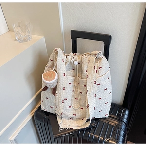 Close-up of waffle texture fabric with red bow print and plush coffee cup charm