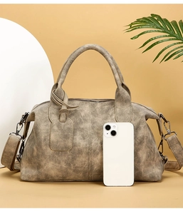 Detail view of vintage pillow bag with matte texture and wide textile shoulder strap