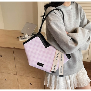 Detail of purple and white checkered tote bag with fashion logo and side ribbon strap
