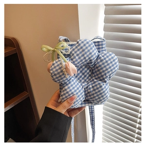 Close-up of blue checkered flower-shaped bag with satin bow and pearl chain detail
