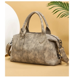 Close-up of a vintage Boston bag with a textured khaki finish and durable top handles