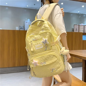 Pale yellow embroidered backpack featuring colorful butterfly patterns and moon plush charm