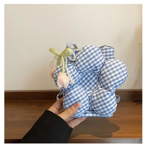 Detail of blue and white checkered flower-shaped crossbody bag with pearl chain and bow