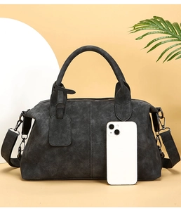 Detailed macro view of black Boston bag with smartphone to demonstrate medium size capacity