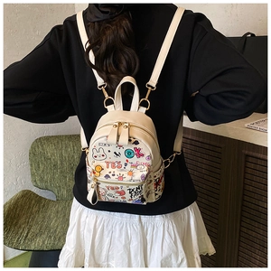 Close-up of white mini backpack with colorful street graffiti and cartoon patterns