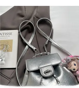Details eines silbernen Metallic-Rucksacks mit Metallkette und Drehverschluss
