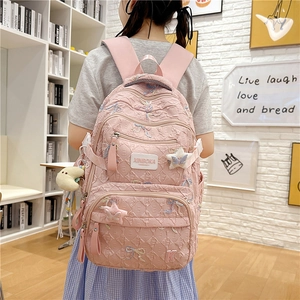 Detail of pink student backpack with sequin butterfly patterns and side star charms