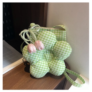 Close-up of flower-shaped green gingham crossbody bag with tulip pendants and pearl chain