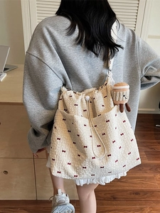 Lightweight cream canvas tote bag with red bow pattern and plush toast charm accessory