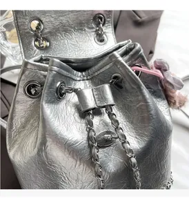 Nahaufnahme des silbernen Rucksacks mit Kordelzug und weichem Plüsch-Anhänger