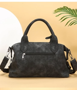 Detail of dark grey retro pillow bag with matte texture and sturdy handles