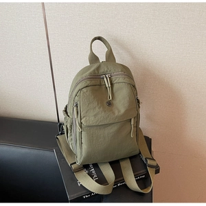 Close-up of military green water-resistant nylon backpack with zippers and side pockets
