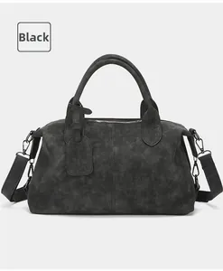 Detail shot of a black vintage Boston bag with top handles and textured synthetic leather