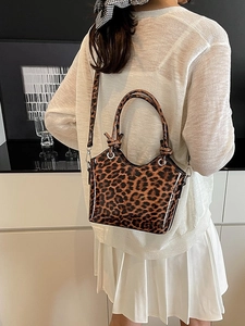 Fashionable leopard print handbag with crossbody strap shown in a modern home setting
