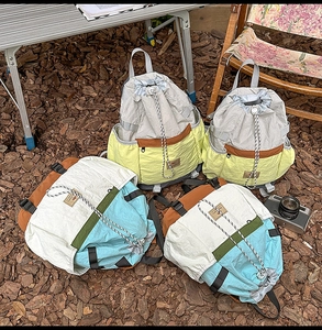 Detail of color-block drawstring backpacks on wood ground for outdoor camping scenery