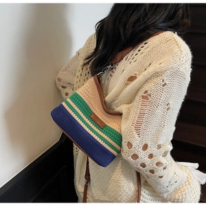 Dettaglio della borsa a tracolla in maglia a righe tricolore con finiture in pelle marrone