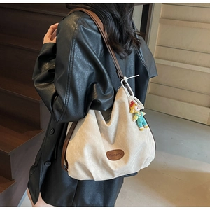 Détail du grand sac cabas en toile crème avec bandoulières en cuir marron
