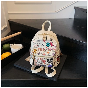 Gros plan du mini sac à dos blanc avec graffitis colorés et fermetures éclair dorées