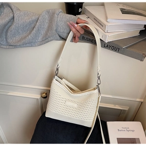 Dettaglio della borsa a rete intrecciata bianca con placca logo e design urbano chic